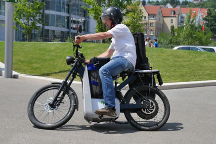 Stefan Adam unterwegs auf Motorroller mit Kameraequipment